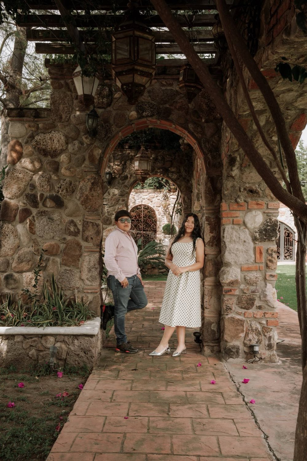 Isabella y Lyzander bajo un arco de piedra